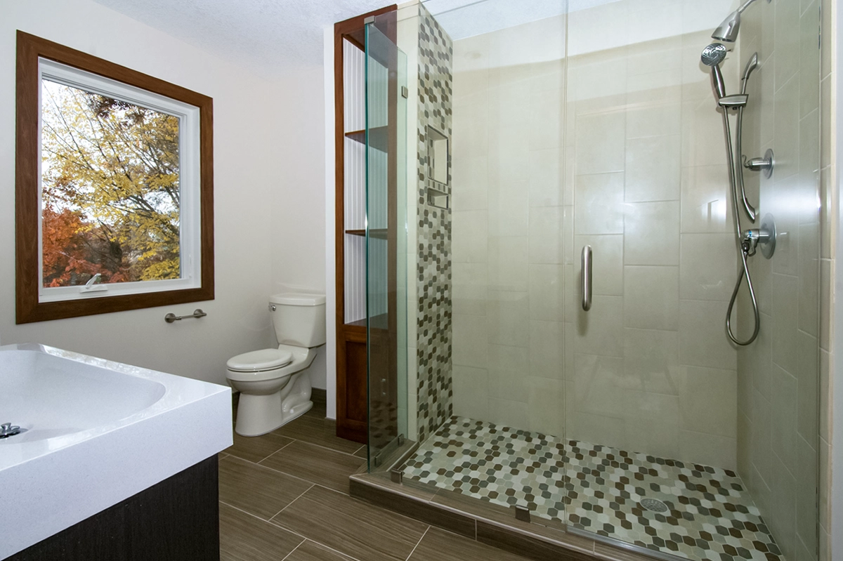 Ham Lake MN custom walk-in shower with frameless glass enclosure, mosaic floor tile, and built-in two-tone storage