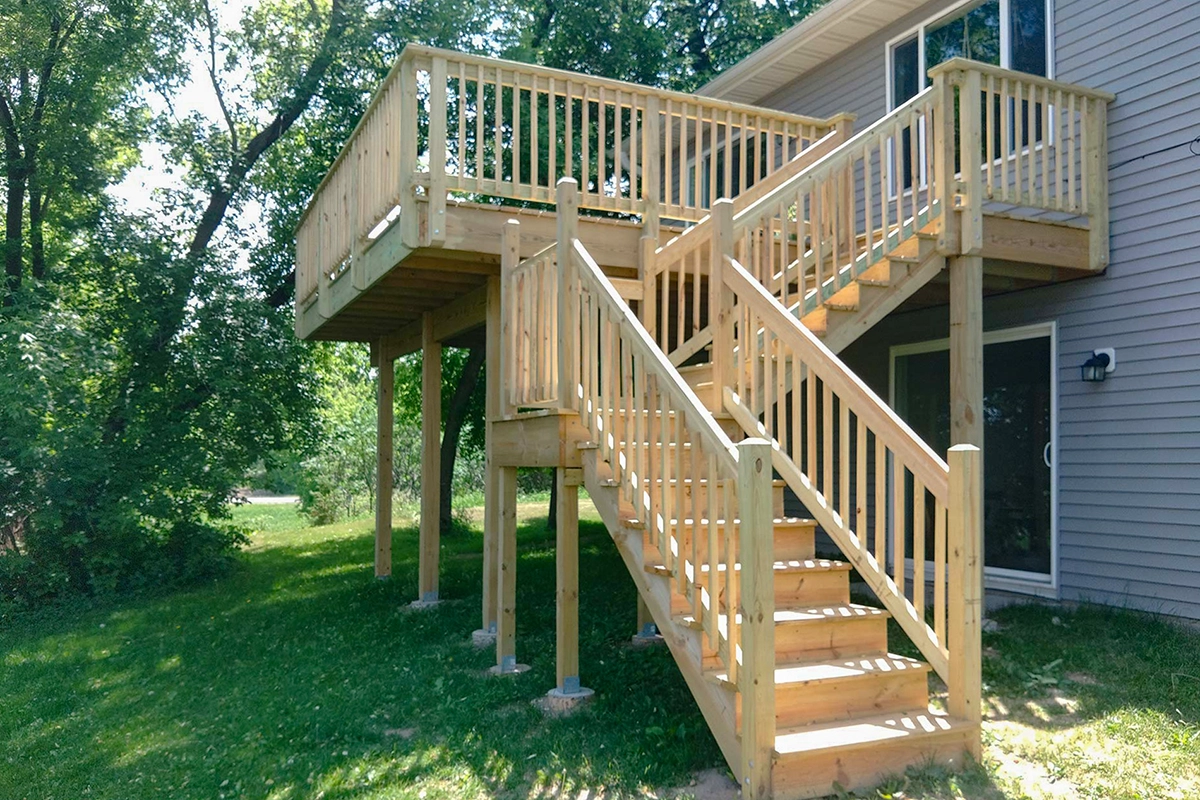 Custom elevated wood deck and switchback staircase built for a home in Isanti