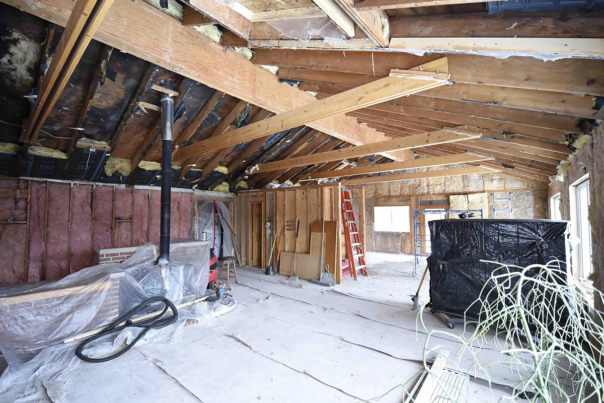 Down-to-the-studs home gut renovation showing exposed roof trusses and structural framing in Ham Lake MN